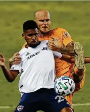  ??  ?? Dynamo defender Kiki Struna, back, tries to get the ball from FC Dallas forward Franco Jara.