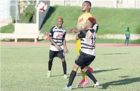  ??  ?? Cavalier’s Chevon Marsh (left) looks on as his teammate Alex Marshall (right) challenges Harbour View FC’s Sheldon McKoy during a Red Stripe Premier League match at the Stadium East Field recently.