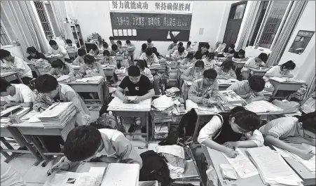  ??  ?? Top: Students study at night at Fuyang No 2 Middle School in Fuyang city, Anhui province. LU QIJIAN / FOR CHINA DAILY Left: Zhou Tong, a high school graduate in Huoqiu county, Anhui, prepares for the gaokao while receiving treatment in hospital. Below: Zhou’s head
teacher, Li Jiasheng, second left, helps him check the gaokao scores on June 23. SHEN SHIGANG / FOR CHINA DAILY