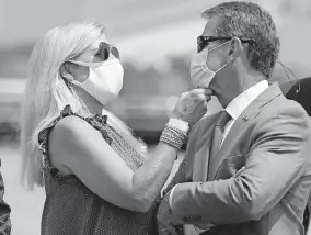  ?? [CURTIS COMPTON/ATLANTA JOURNAL-CONSTITUTI­ON] ?? Georgia Gov. Brian Kemp has his mask adjusted by first lady Marty Kemp while waiting Wednesday for President Donald Trump to arrive at Hartsfield-jackson Internatio­nal Airport. Kemp advocates for mask use but is not allowing any cities to mandate it.