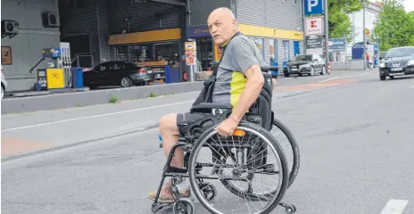  ?? FOTO: ANDREAS BRÜCKEN ?? Franz Nemec überquert in seinem Rollstuhl die Memminger Straße in Neu-Ulm: Die Stadt sei nicht barrierefr­ei, moniert er.