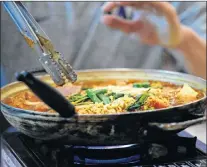  ?? AP PHOTO ?? Budae jjigae, or “army stew,” simmers as it sits atop a heating plate at a Korean restaurant in Shoreline, Wash.