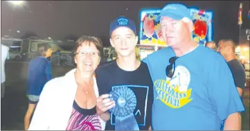  ?? MARJORIE COMEAU ?? Proud grandparen­ts, Marjorie and Ronnie Comeau, stand beside Tyler on his winning day at the Galax Music Festival