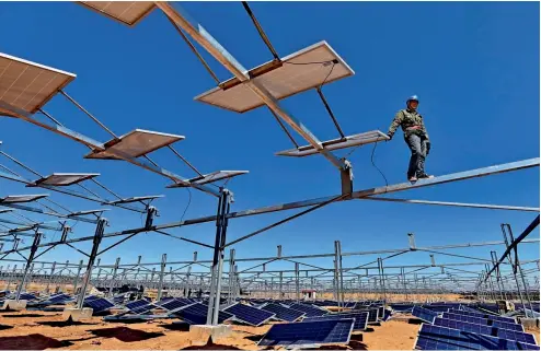  ??  ?? Planta de energía fotovoltai­ca en construcci­ón en el desierto Kubuqi.