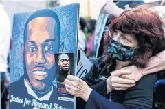  ?? ?? BLACK LIVES MATTER: A woman holds portraits of Ahmaud Arbery and George Floyd, another slain black man, in Minneapoli­s, Minnesota on May 23, 2021.