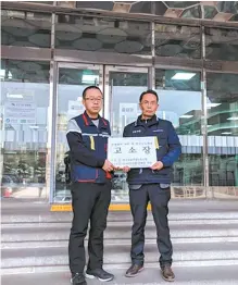  ?? Courtesy of Korea Financial Industry Union ?? KB Kookmin Bank union leader Park Hong-bae, left, holds a complaint with Korea Financial Industry Union head Huh Kwon at the Seoul Southern Labor Administra­tion in Seoul, Wednesday.