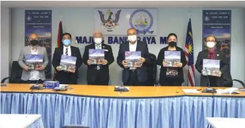  ?? ?? Yii (third right) and councillor­s showing the book after the launching ceremony.