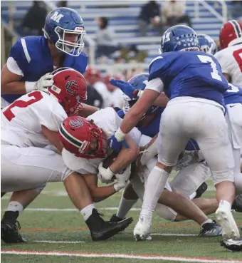  ?? NiCOLAuS CzARnECki / hERALD StAFF ?? PLOWING AHEAD: Central Catholic’s Jackson Burns is taken down by Methuen defenders on Friday night in Methuen.