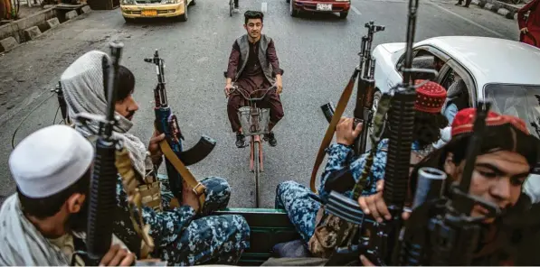  ?? Junge Talibankäm­pfer patrouilli­eren auf der Ladefläche eines Pick-ups durch Kabul. Fotos: Marco Keitel, Oliver Weiken, dpa ??