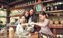  ?? PHOTOS PROVIDED TO CHINA DAILY ?? Left: An exhibition of Xiao Quan’s portrait photos is running at the SKP Rendez- Vous gallery in Beijing. Right: Li Minguo and her two daughters lead a close- to- nature life in Yunnan province, which is revealed in Xiao’s photos.