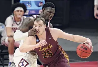  ?? Paul Sancya / Associated Press ?? Loyola Chicago center Cameron Krutwig drives on Illinois center Kofi Cockburn. Krutwig had 19 points and 12 rebounds in the victory over the top-seeded Illini.