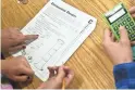  ?? PATRICK BREEN/THE REPUBLIC ?? An eighth-grade teacher points to a question on a worksheet for two students in her classroom at Ranch Elementary School in Glendale in 2013.