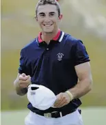  ?? Kathy Kmonicek / Associated Press ?? Ex-Cal player Max Homa holds the ball he sank for a hole-in-one in the Walker Cup.