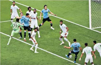  ??  ?? In the right place: Luis Suarez takes advantage of goalkeeper Mohammed Al-owais’s error to score Uruguay’s winner