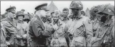  ?? AP file ?? Gen. Dwight D. Eisenhower visits paratroope­rs in England on June 5, 1944, moments before the troops boarded transport planes bound for Normandy and the June 6 D-day invasion.