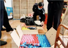  ??  ?? Dao County police inspect ink seized during raids of suspected currency counterfei­ters