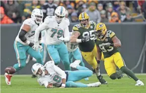  ?? DAN POWERS/USA TODAY NETWORK-WISCONSIN ?? Packers linebacker Reggie Gilbert (93) moves in to recover a fumble by Dolphins quarterbac­k Brock Osweiler (8) in the first quarter at Lambeau Field.