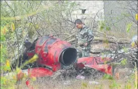  ?? PTI ?? An officer inspects the charred remains of an aircraft after two planes of IAF aerobatic team Surya Kiran crashed near the Yelahanka airbase in Bengaluru on Tuesday.