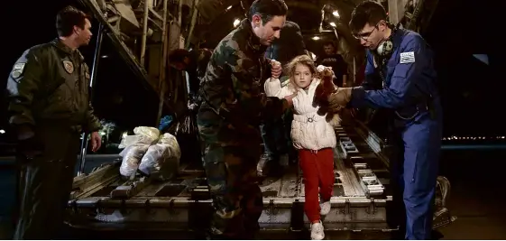  ?? REUTERS ?? AMAN (center) and his daughter, both rescued from the Norman Atlantic ferry, disembark from a Greek Airforce C-130 military cargo aircraft at the Elefsina military airport near Athens, Dec. 29.