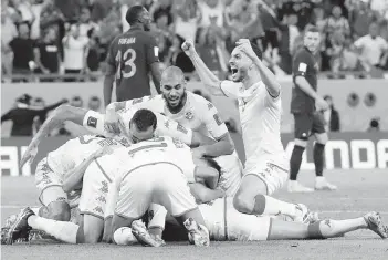  ?? MARTIN MEISSNER AP ?? Players of Tunisia celebrate after Wahbi Khazri scored what would prove to be the winning goal against France. It was only the third victory at a World Cup tournament for the north African nation.