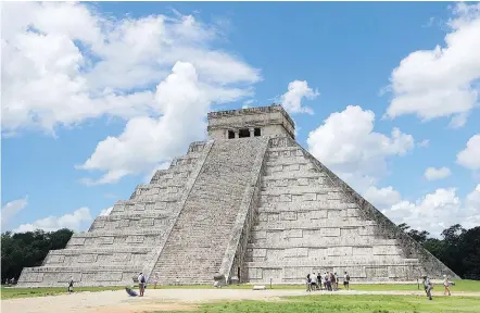  ?? — PHOTOS: THE ASSOCIATED PRESS ?? Tourists are dwarfed by El Castillo at the Chichen-Itza ruins in Yucatan.