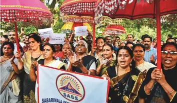  ?? AP ?? Hindu women hold decorative umbrellas, used for temple procession­s, as they arrive for a protest against the recent Supreme Court verdict in New Delhi yesterday.