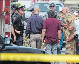  ?? JOHN RENNISON THE HAMILTON SPECTATOR ?? Police and fire officials talk to two officials from McMaster’s health physics department at a business on Strathearn­e Ave. on Tuesday.