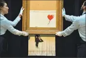  ?? Ben Stansall AFP/Getty Images ?? THE BANKSY WORK auctioned in London Oct. 5 as “Girl With Balloon” is now “Love Is in the Bin.”