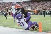  ?? CAROLYN KASTER/AP ?? Bengals receiver Tee Higgins reaches for the end zone to score a touchdown over Vikings cornerback Akayleb Evans on Saturday in Cincinnati.