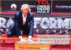  ??  ?? Bay places his hands in cement during a ceremony in the forecourt of the TCL Chinese theatre in Los Angeles, California, on Tuesday. — Reuters photo