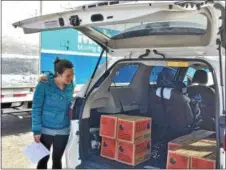  ??  ?? Erin Corrigan checks the number of cases of Girl Scout cookies in her car at the Girl Scouts of Northeaste­rn New York cookie delivery in Clifton Park on Friday.