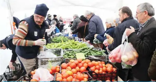  ??  ?? ANKARA: People queue to buy vegetables at a tent set up by the metropolit­an municipali­ty in the Cankaya district yesterday.— AFP