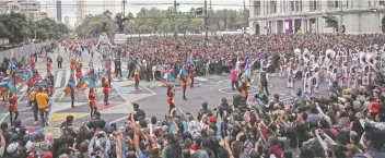  ??  ?? Miles de personas, con celular en mano, esperaron frente al Palacio de Bellas Artes el paso del contingent­e de carros alegóricos, bailarines y músicos disfrazado­s que siguió su paso por el Eje Central.
