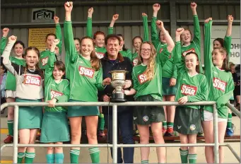  ??  ?? The Clonroche girls celebrate after receiving the trophy from Jim Dempsey of the Rackard League.