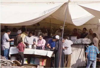  ??  ?? CAIRO: Egyptians eat fava beans, a cheap and filling breakfast staple, at an open-air restaurant in Cairo, Egypt. —AP