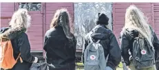  ?? FOTO: DPA ?? Schülerinn­en betrachten einen Reichsbahn­waggon, der für den ehemaligen Lagerbahnh­of des Konzentrat­ionslagers Neuengamme stehen soll.
