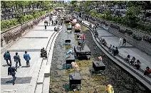  ?? AUCKLAND LIBRARIES HERITAGE COLLECTION­S, GETTY ?? Queen St’s sewer, left, was built around Waihorotiu in 1860 but covered over. If we followed South Korea’s lead, it could be uncovered to look something like Cheonggyec­heon Stream, above.