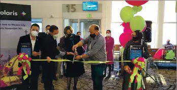  ?? JEREMY HUYNH ?? Alejandra Bologna Zubikarai, Consul General of
Mexico in San Jose (behind scissors) and San Jose Director of Aviation John Aitken (right) join other dignitarie­s to cut a ribbon marking the start of Volaris service between San Jose and Mexico City.