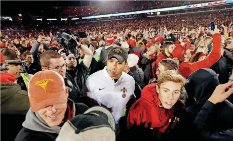  ?? [AP PHOTO] ?? Iowa State coach Matt Campbell works his way through the mob of celebratin­g Cyclone fans after a 30-14 victory over West Virginia on Oct. 13.