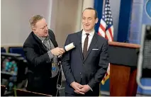  ?? PHOTO: REUTERS ?? White House press secretary Sean Spicer removes lint from senior White House adviser Stephen Miller’s jacket as he waits to go on the air in the White House briefing room.