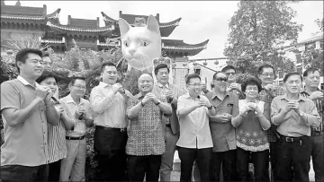  ??  ?? Dr Sim (front fourth right) together with Wong (on his right), Chan (fifth left) and other community leaders pose for a group photo after dressing up the White Cat in Padungan.