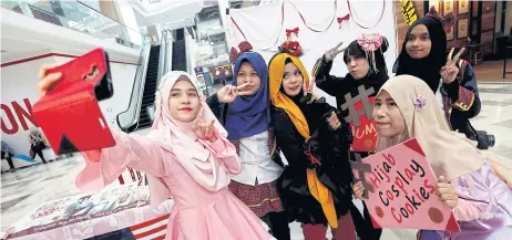  ??  ?? Cosplayers take a selfie at the Malaysian mall event.