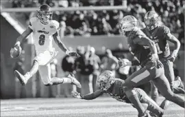  ?? David Stephenson Associated Press ?? LAMAR JACKSON, the reigning Heisman Trophy winner, leaves Kentucky defenders grasping for air as he hops for a big gain in Louisville’s victory.