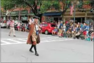  ??  ?? Benjamin Franklin, played by local actor and Saratoga Springs native Michael Wilcox, marching in a parade during the 10th annual Saratoga’s All-American Celebratio­n on Tuesday in downtown Saratoga Springs.