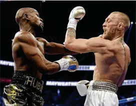  ?? ISAAC BREKKEN / ASSOCIATED PRESS ?? FloydMaywe­ather Jr. (left) went into retirement undefeated and ConorMcGre­gor had a respectabl­e showing in his boxing debut early Sunday.