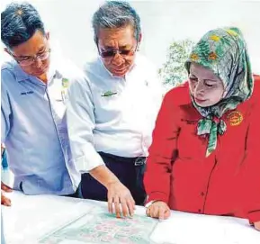  ?? [ FOTO JANNAH KHO / BH ] ?? Jamilah (kanan) meneliti Pelan Pembanguna­n CENTEXS sambil diberikan penjelasan oleh Pengarah Yayasan Sarawak, Azmi Bujang (tengah).