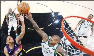  ?? (AP) ?? Phoenix Suns’ Cameron Payne (15) shoots over Milwaukee Bucks’ P.J. Tucker (17) during the first half of Game 1 of basketball’s NBA Finals in Phoenix.