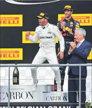  ?? GEERT VANDEN WIJNGAERT / AP ?? Mercedes driver Lewis Hamilton celebrates on the podium after winning the Belgian Formula One Grand Prix in Spa-Francorcha­mps, Belgium, on Sunday. Ferrari’s Sebastian Vettel placed second and Red Bull driver Daniel Ricciardo finished third.