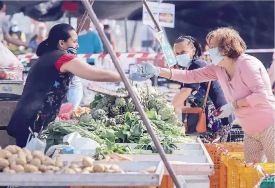  ?? Foto: A. García ?? Gemüseeink­auf mit reichlich Sicherheit­sabstand: Einzelne Wochenmärk­te haben unter strengen Auflagen wieder geöffnet.