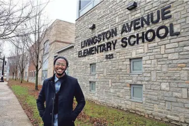  ?? FRED SQUILLANTE/COLUMBUS DISPATCH ?? Devin Thomas, a rapper known as Trek Manifest, is pictured in front of his alma mater Livingston Elementary School. The artist’s roots in the Driving Park neighborho­od have inspired his work.